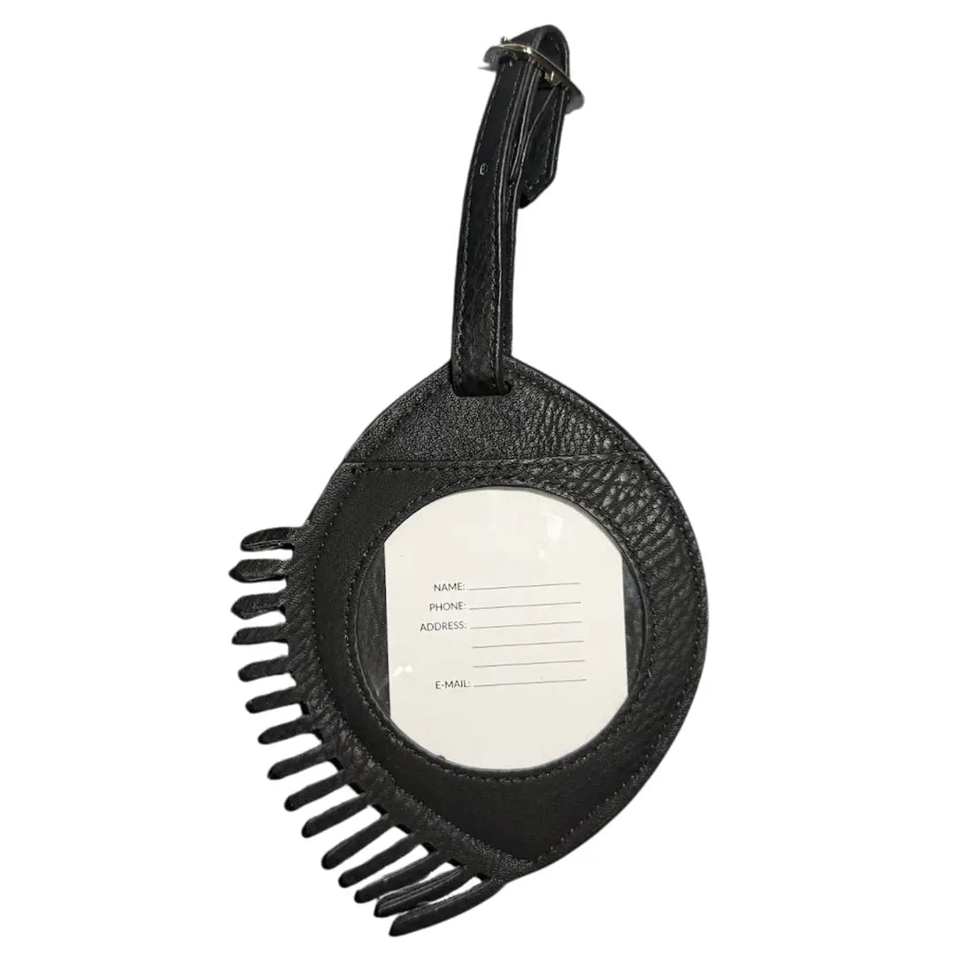 A black textured leather luggage tag with a fringed edge and a central clear window displaying a white paper insert with fields for name, phone, address, and email.