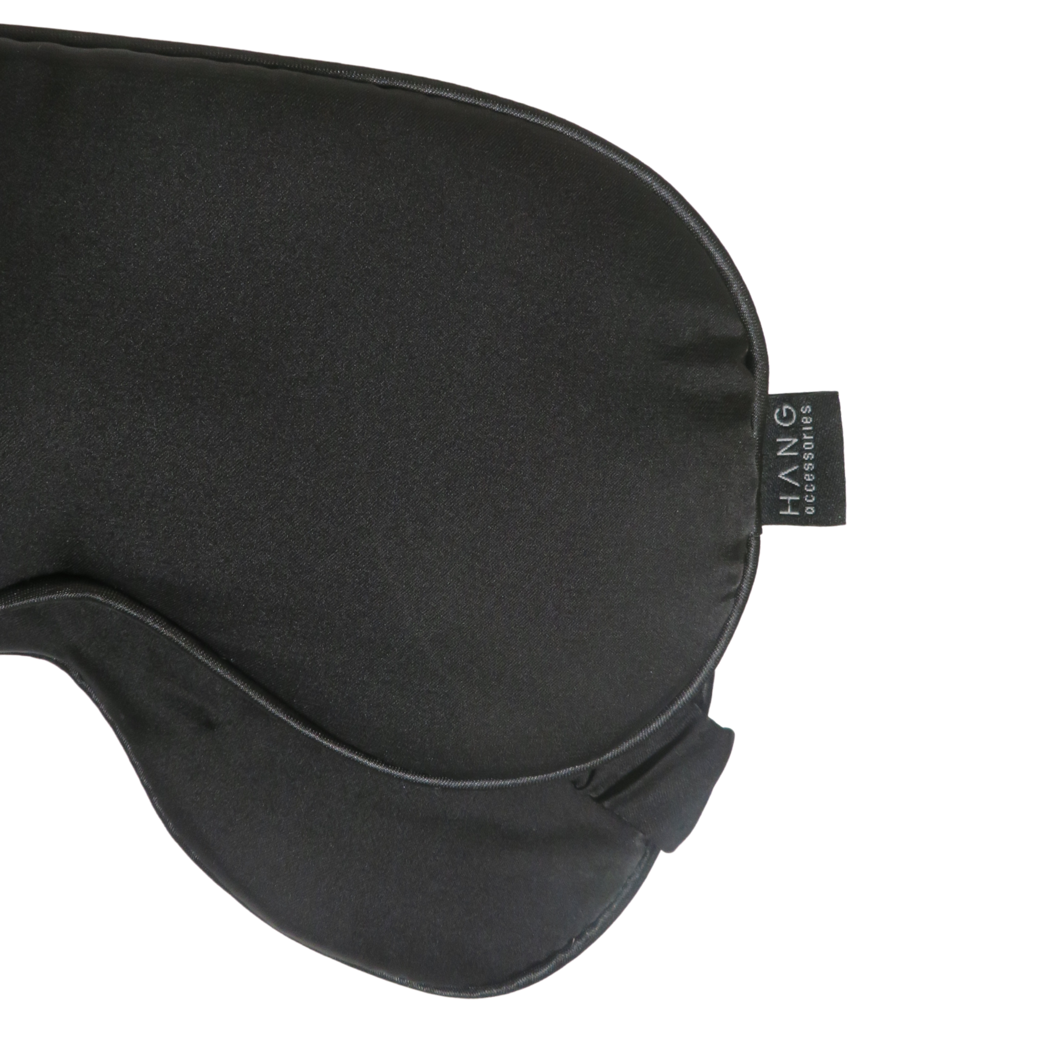 Close-up of a black sleep mask with a small black brand tag.