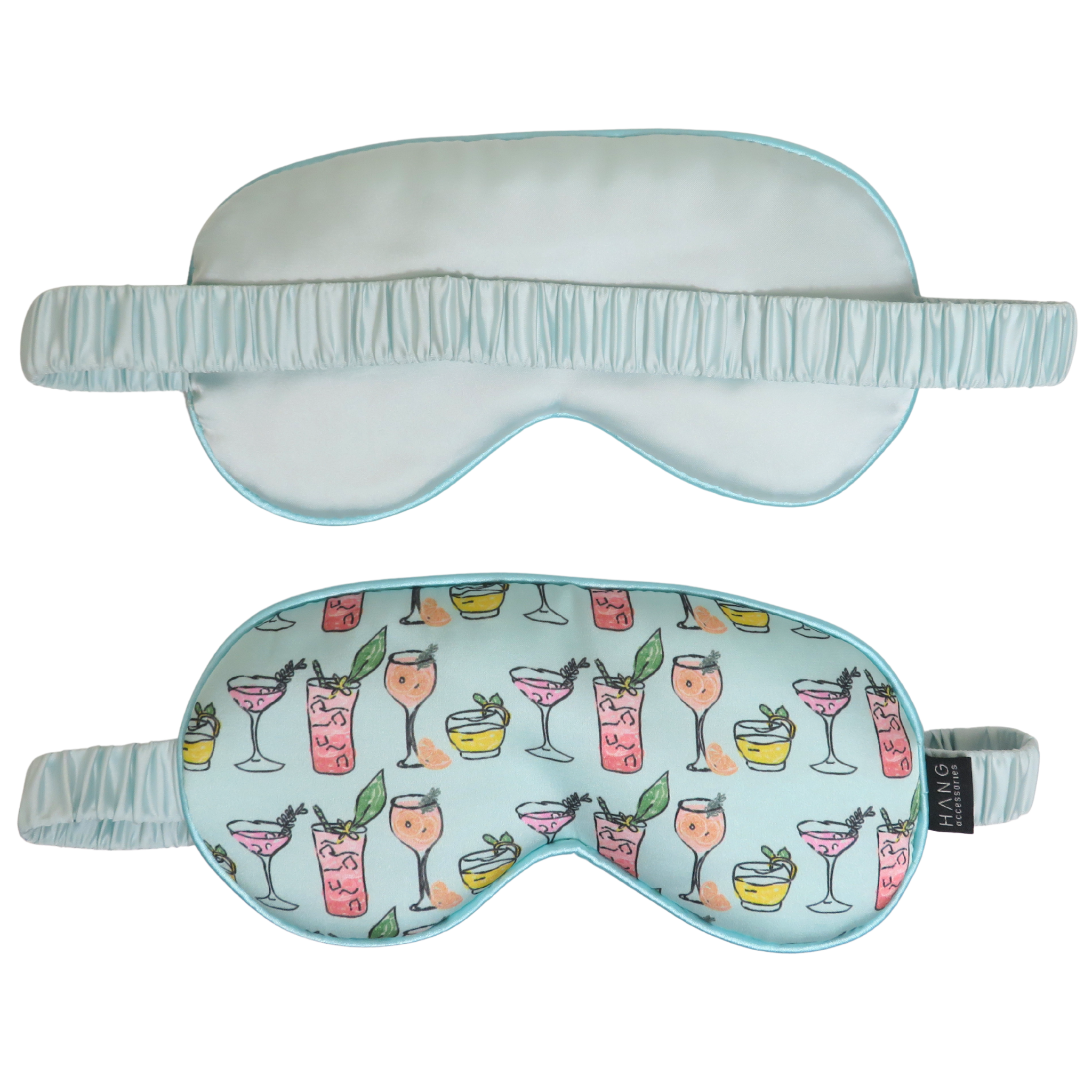 Two sleep masks on a plain white background, one solid pale aqua and the other with a pale aqua base printed with colorful cocktail illustrations. Both have matching elastic straps.