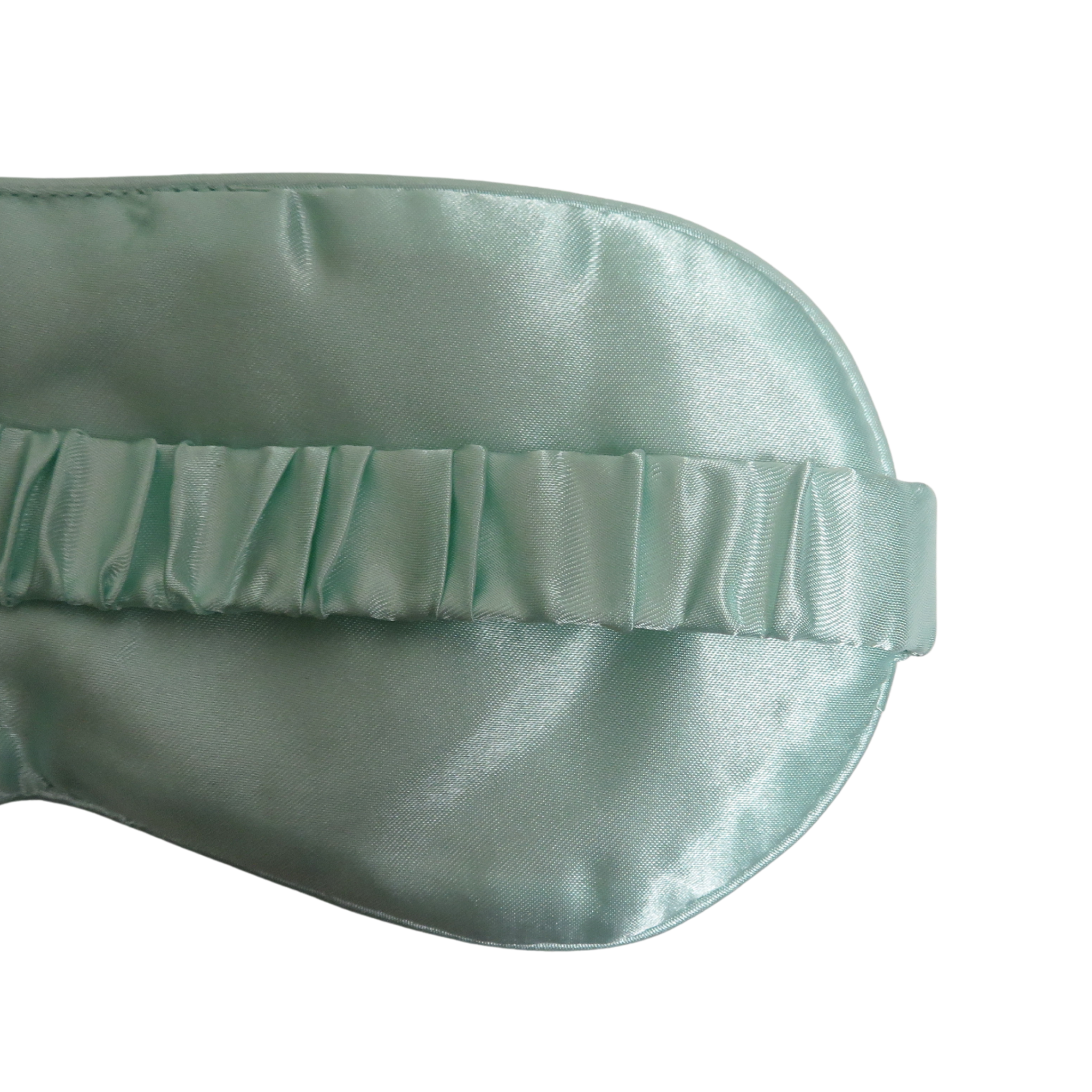 A close-up of a mint blue satin sleep mask showing the eye-cushion shape and elasticized eye strap on a plain white background.