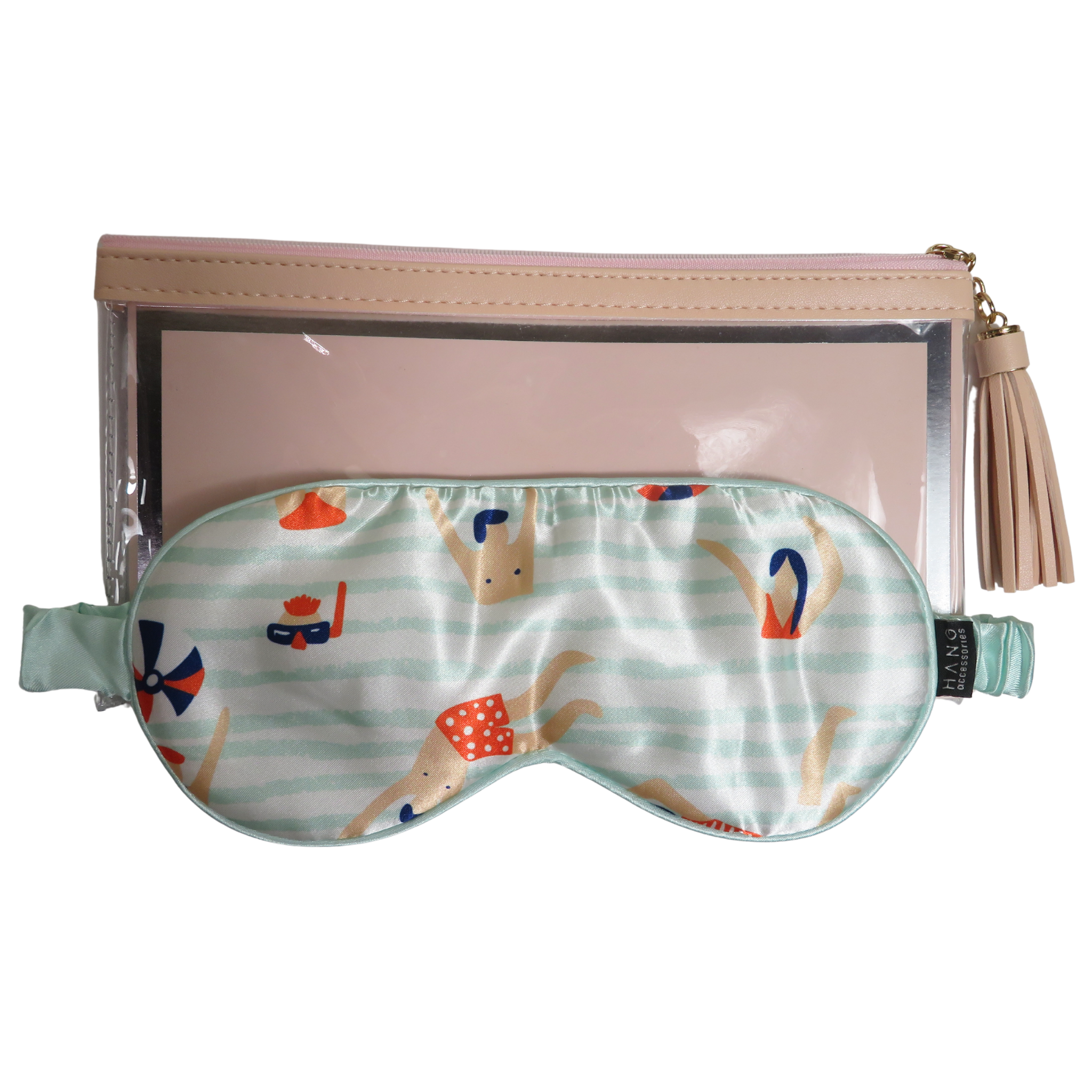 A mint green satin sleep mask with a beach-themed print, displayed in front of a clear zippered pouch with a beige tassel zipper pull.