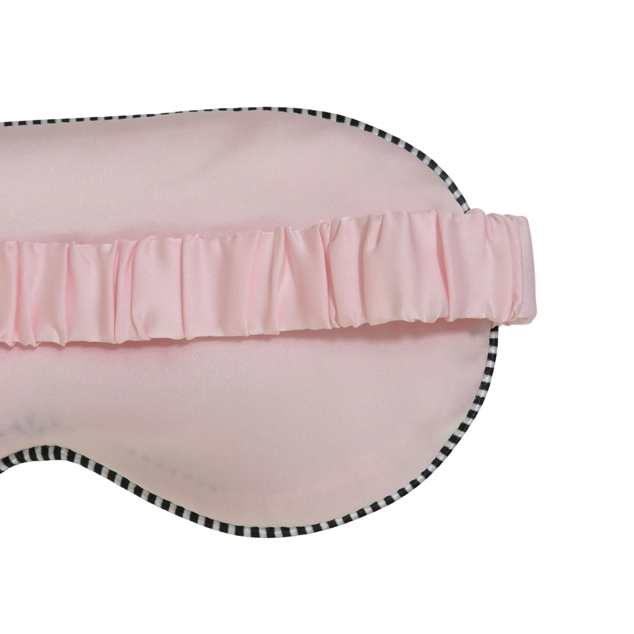 A close-up of a light pink sleep mask with a ruffled elastic band and a black-and-white checkered edge trim, shown on a plain white background.