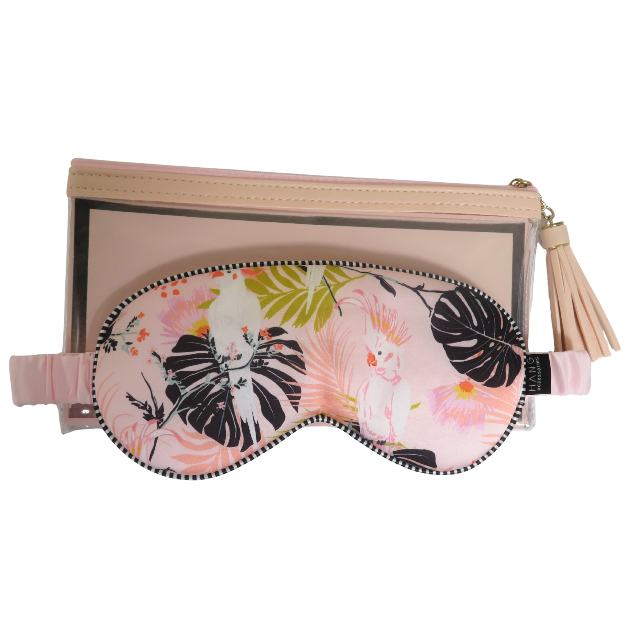 A pink tropical-print sleep mask with a black dotted zipper and elastic strap, displayed in front of a matching beige zippered pouch with a tassel zipper pull on a white background.