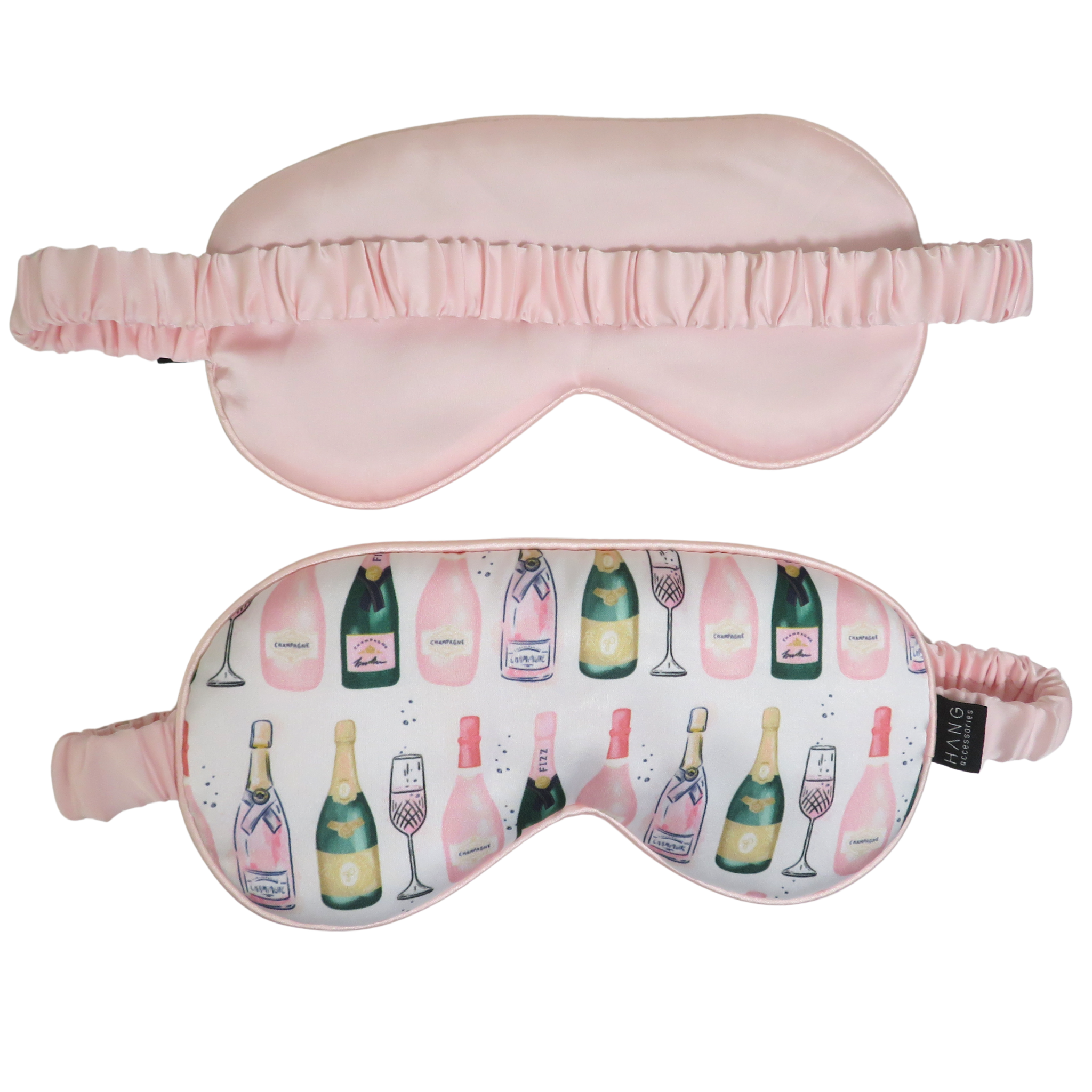Two sleep masks shown on a plain white background: a solid light pink mask above and a white mask below with a repeating champagne bottle and pink champagne glass print, both with pink elastic straps.