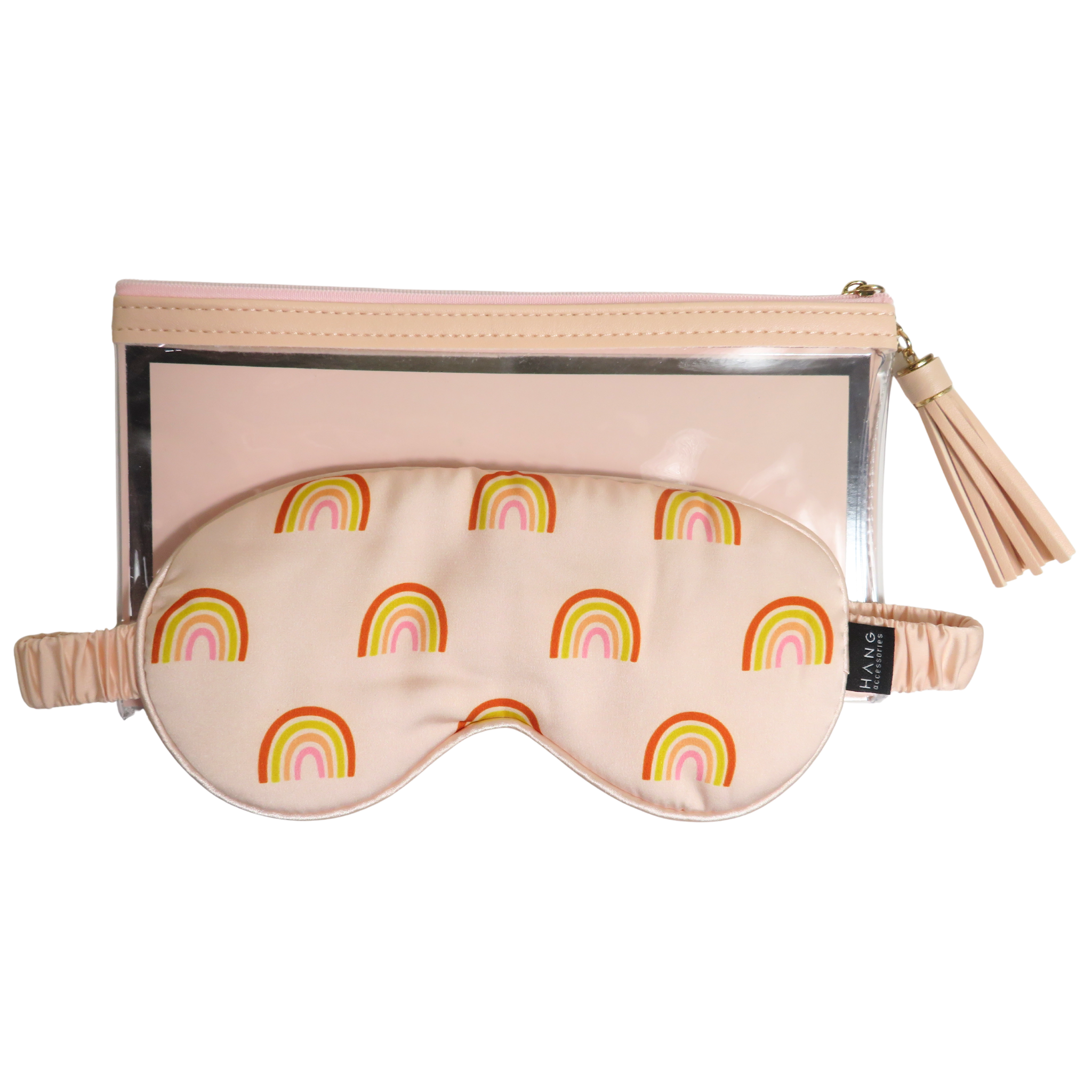 A blush pink sleep mask with a colorful rainbow pattern, shown in front of a matching zippered pouch with a tassel zipper pull.