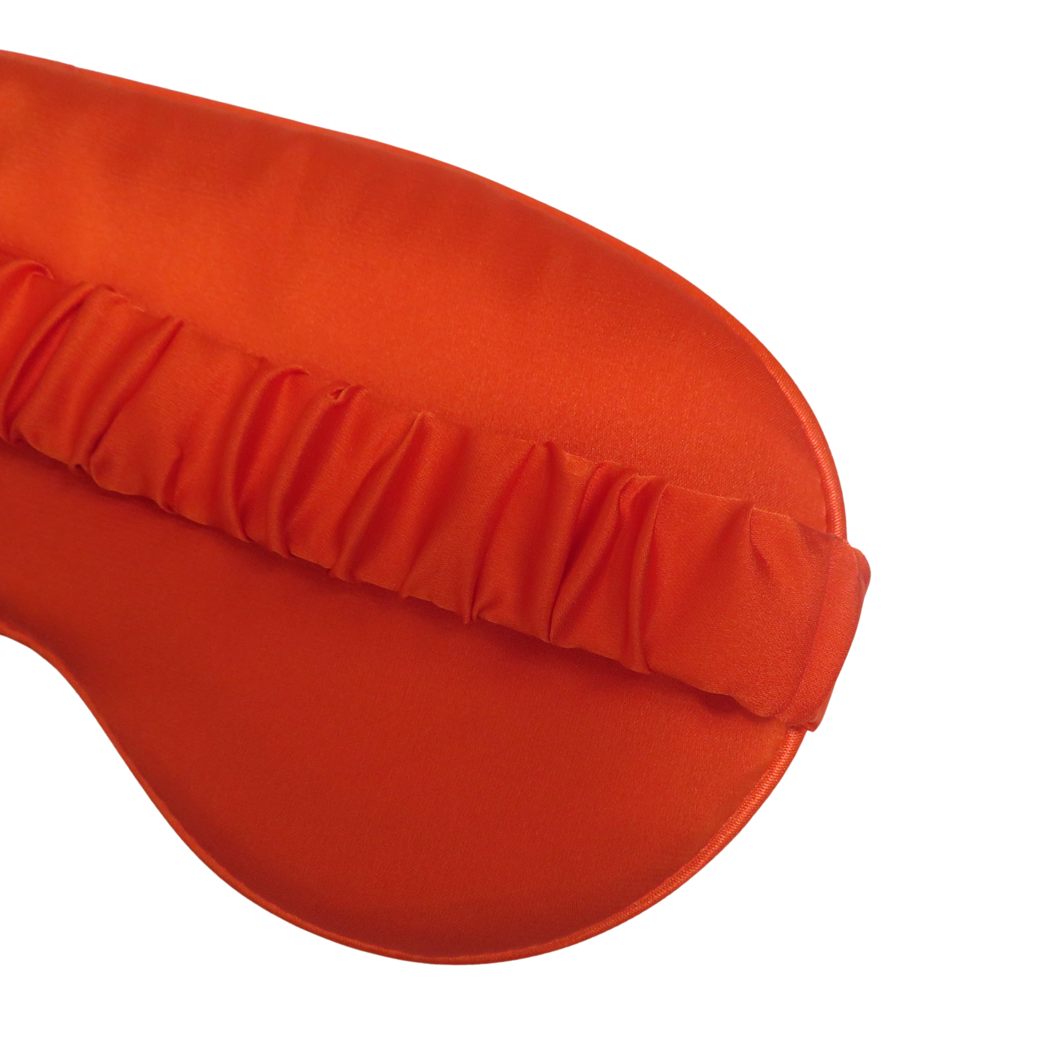 A close-up of an orange sleep mask with a gathered elastic band, shown on a solid white background.