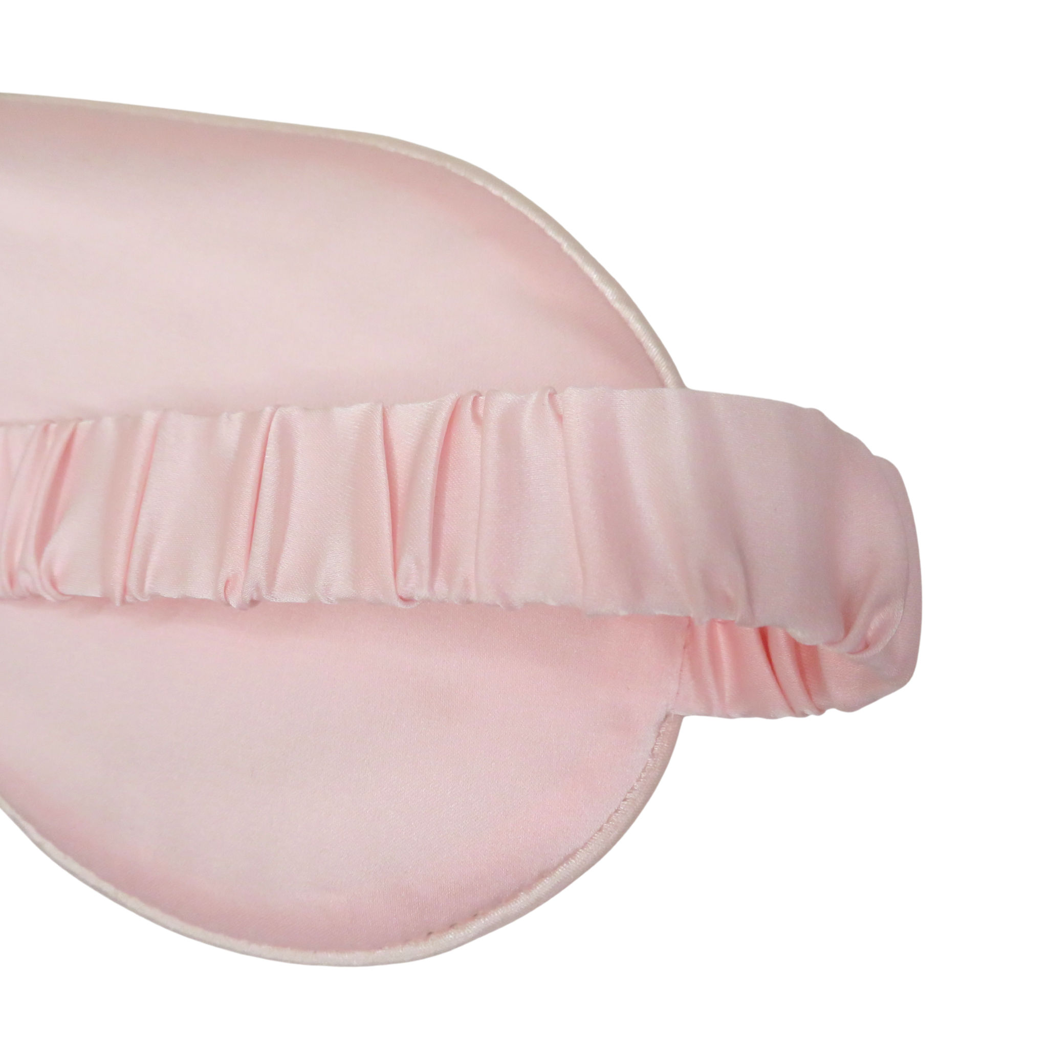 A close-up of a light pink satin sleep mask with a matching elasticized headband, shown on a plain white background.
